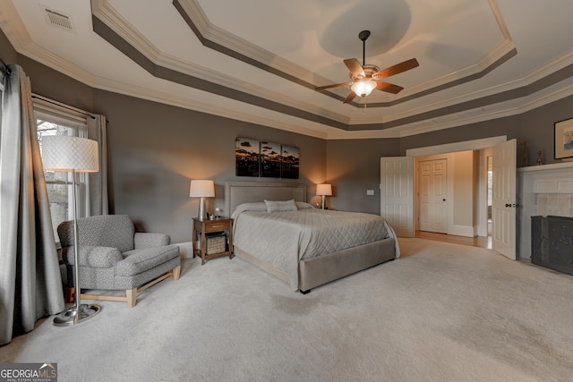 bedroom with ceiling fan, a raised ceiling, light colored carpet, and crown molding