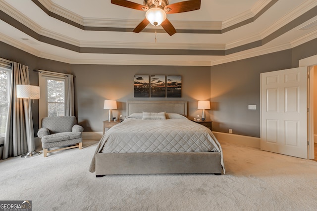 bedroom with carpet flooring, a raised ceiling, ceiling fan, and crown molding