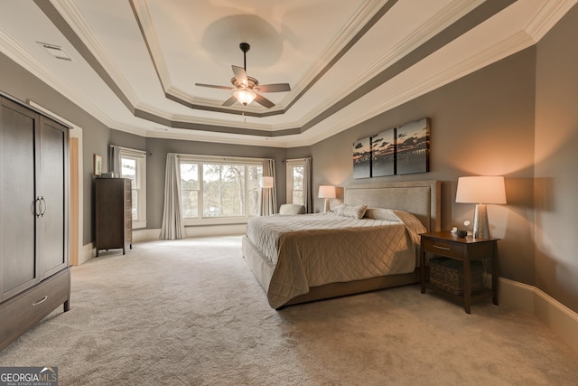 carpeted bedroom with ceiling fan, a raised ceiling, and crown molding