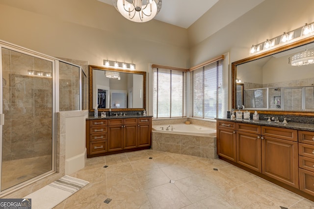 bathroom featuring tile patterned floors, plus walk in shower, vanity, and a notable chandelier