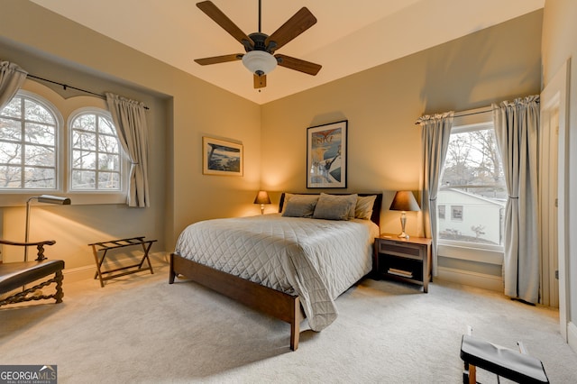 carpeted bedroom with ceiling fan and multiple windows