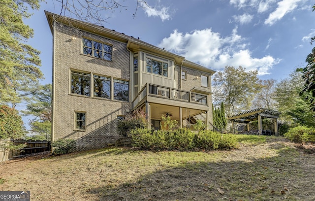 rear view of house with a balcony and a pergola