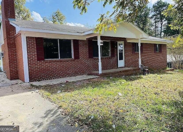 view of front of home with a porch and a front yard