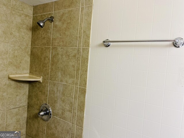 interior details featuring tiled shower