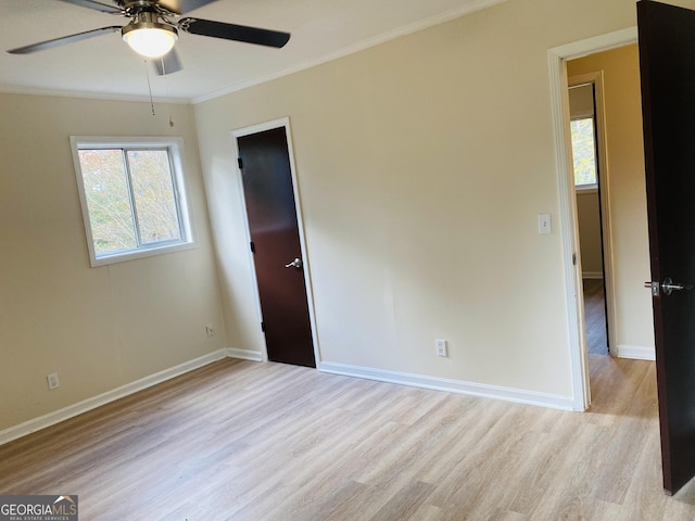 spare room with ceiling fan, ornamental molding, and light wood-type flooring