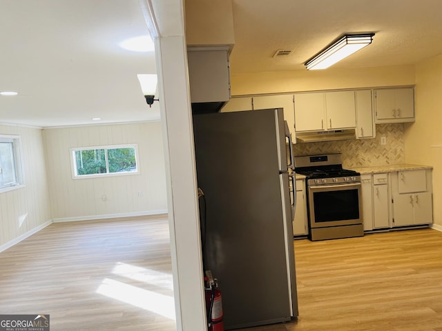 kitchen with backsplash, light hardwood / wood-style flooring, and stainless steel appliances