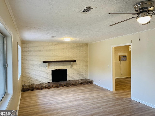 unfurnished living room with a fireplace, crown molding, and light hardwood / wood-style flooring