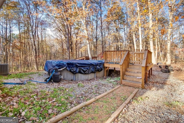 view of yard with a pool side deck and central AC