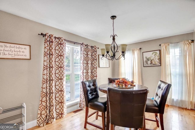 dining room with a chandelier, light hardwood / wood-style flooring, and a healthy amount of sunlight