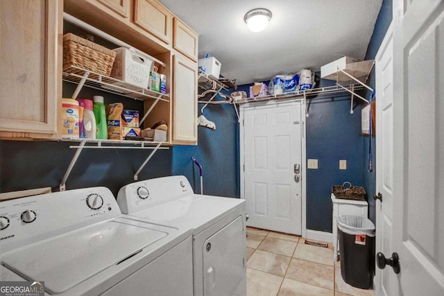 laundry room featuring washer and dryer, cabinets, and light tile patterned floors