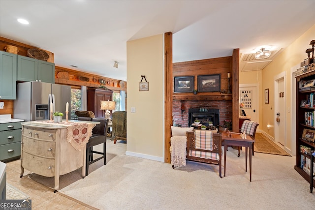 kitchen with a kitchen bar, stainless steel refrigerator with ice dispenser, and light carpet