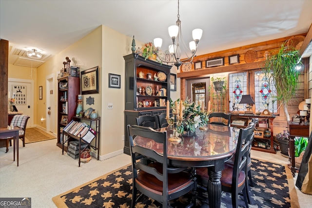 dining area with light carpet and an inviting chandelier