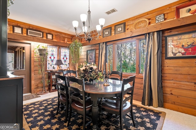 dining area featuring an inviting chandelier and wood walls