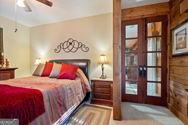 bedroom with french doors, light colored carpet, ceiling fan, and wooden walls