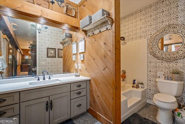 full bathroom with vanity, tile patterned floors, wood walls, toilet, and shower / bathing tub combination