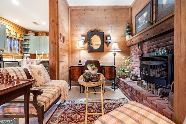 living room with carpet, a brick fireplace, and wooden walls