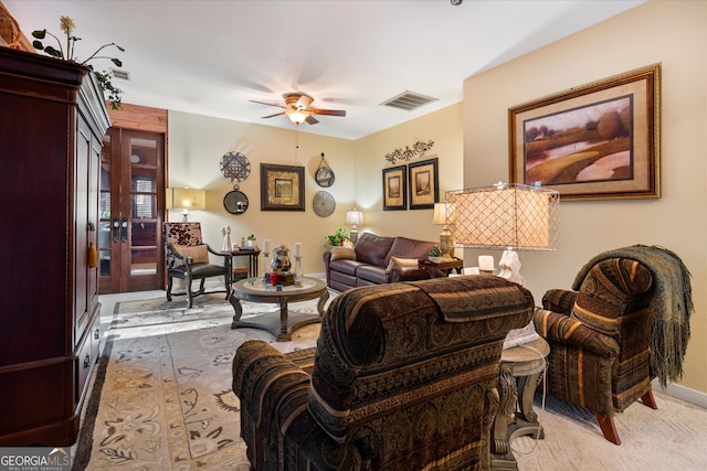 living room featuring ceiling fan, light carpet, and french doors