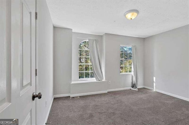 spare room with dark carpet