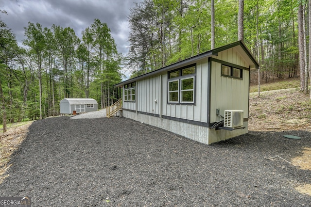 view of property exterior with cooling unit and a storage unit