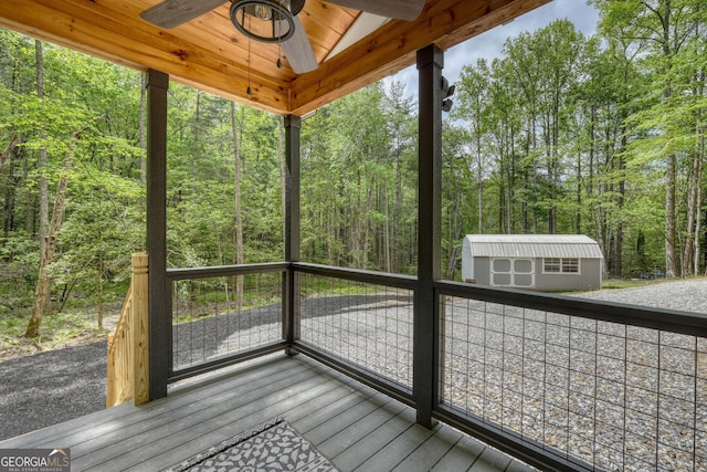 wooden terrace featuring ceiling fan and a storage unit