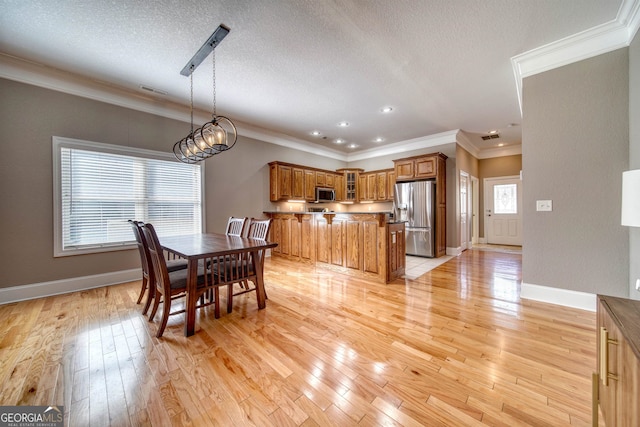 dining space with a notable chandelier, crown molding, a textured ceiling, and light hardwood / wood-style flooring