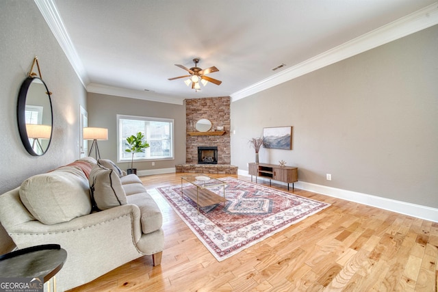 living room featuring crown molding, a fireplace, ceiling fan, and hardwood / wood-style flooring