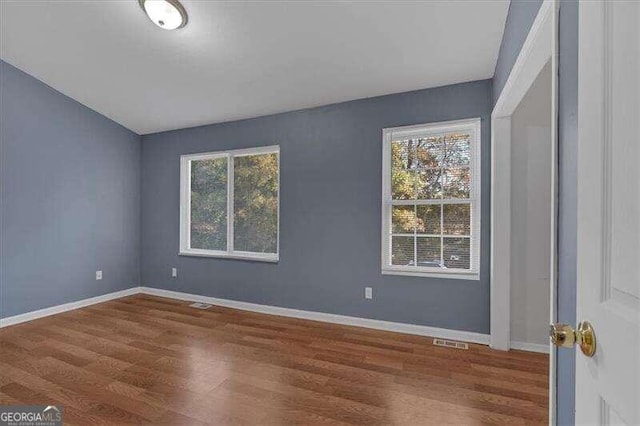 unfurnished room featuring hardwood / wood-style floors and a healthy amount of sunlight