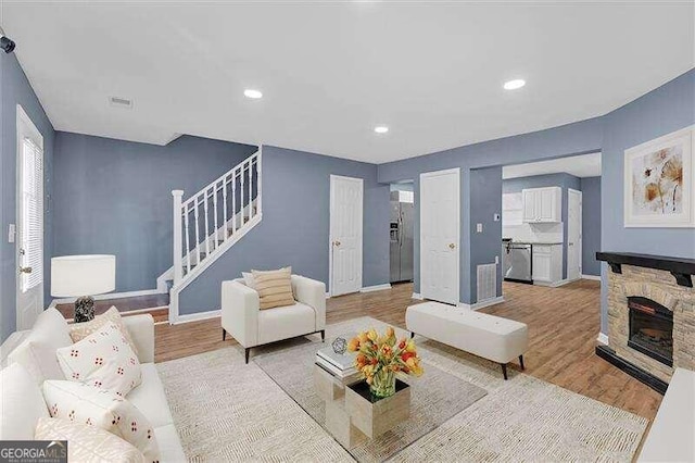 living room featuring a fireplace, light hardwood / wood-style floors, and a healthy amount of sunlight