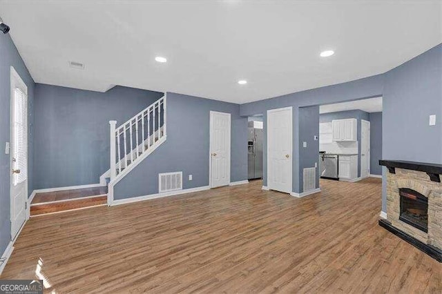 unfurnished living room featuring a fireplace and light hardwood / wood-style flooring