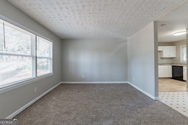 carpeted empty room with a wealth of natural light and ceiling fan