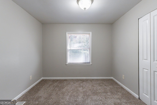 unfurnished bedroom with carpet flooring, ceiling fan, and a closet