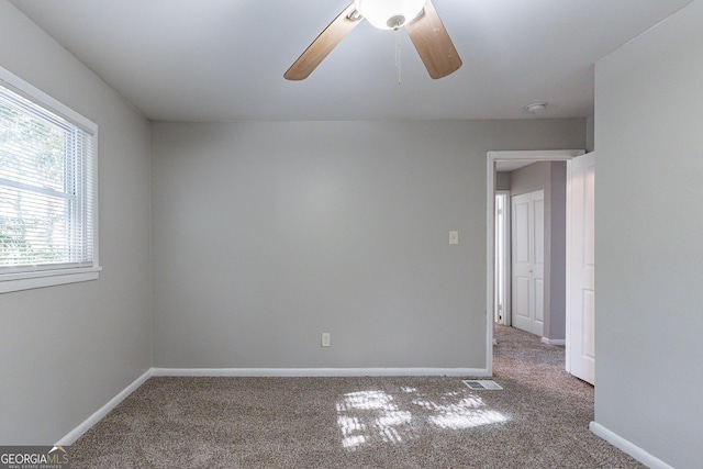 carpeted spare room featuring ceiling fan