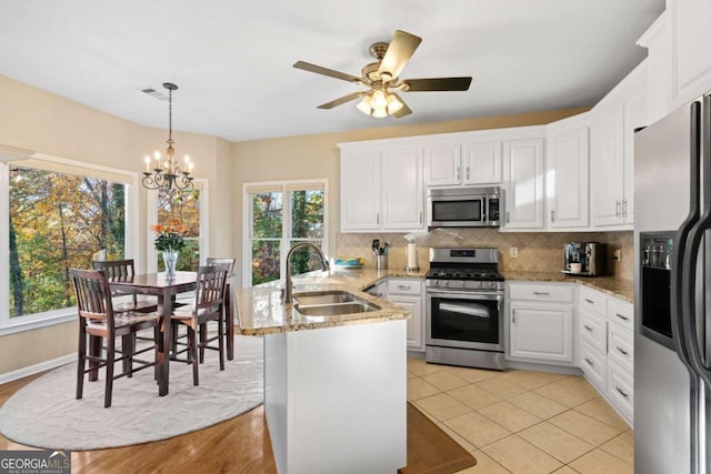 kitchen with appliances with stainless steel finishes, white cabinetry, a wealth of natural light, and sink