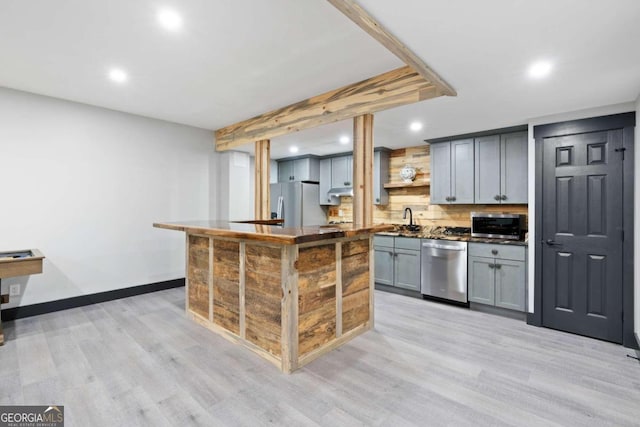 kitchen with a center island, gray cabinets, light hardwood / wood-style floors, and appliances with stainless steel finishes