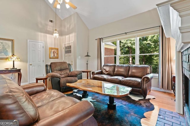 living room with light wood-type flooring, high vaulted ceiling, and ceiling fan