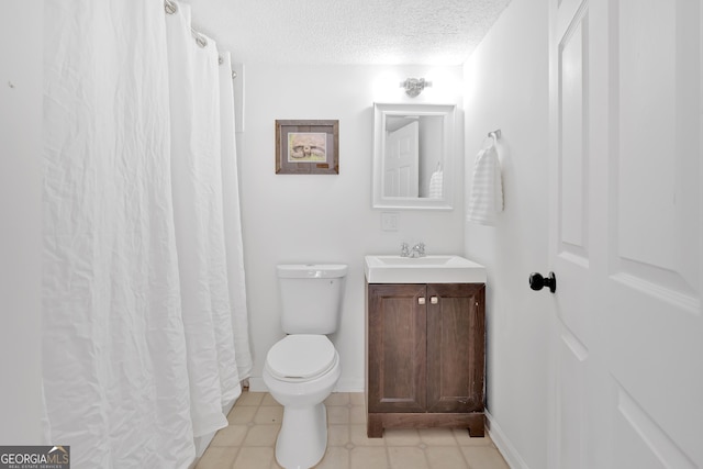 bathroom featuring vanity, a textured ceiling, and toilet