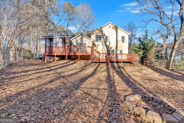 rear view of property with a wooden deck and an outdoor fire pit