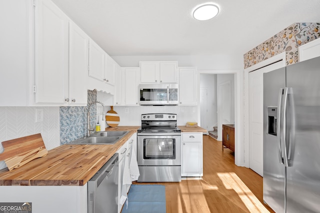 kitchen featuring white cabinetry, sink, wooden counters, and appliances with stainless steel finishes