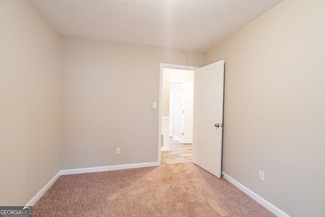 carpeted spare room featuring a textured ceiling