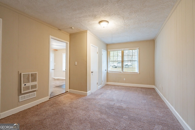 unfurnished bedroom with light carpet, a textured ceiling, heating unit, and crown molding