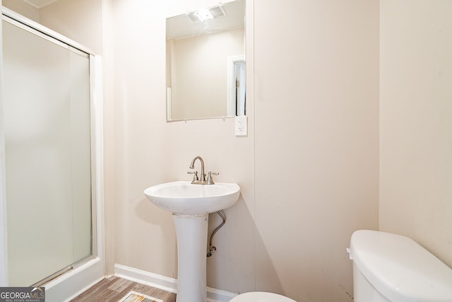 bathroom with hardwood / wood-style flooring and toilet