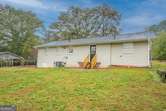 back of house with a yard and central AC unit