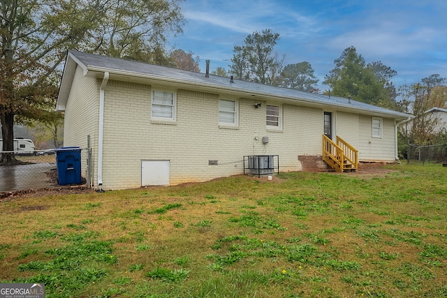 rear view of house featuring a yard