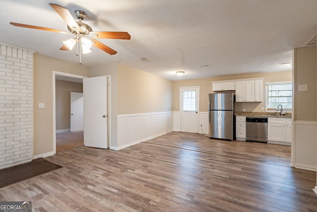 kitchen featuring white cabinets, a healthy amount of sunlight, stainless steel appliances, and hardwood / wood-style floors