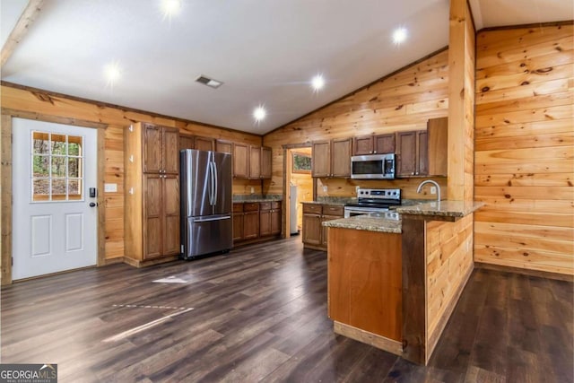 kitchen with lofted ceiling, dark hardwood / wood-style flooring, kitchen peninsula, and stainless steel appliances