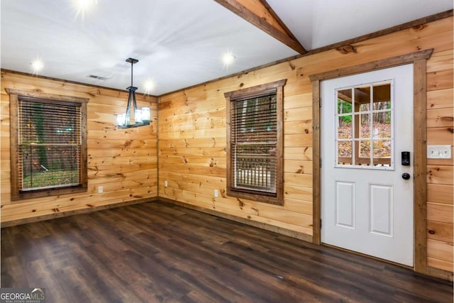 unfurnished dining area with beamed ceiling, dark wood-type flooring, and wooden walls