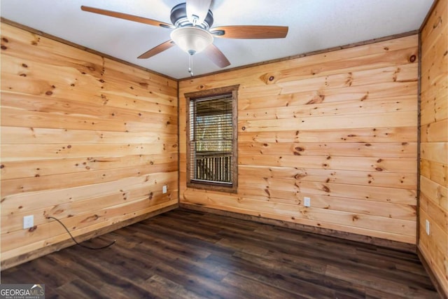 empty room featuring wooden walls, ceiling fan, and dark wood-type flooring