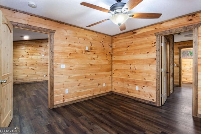 unfurnished room with ceiling fan, dark wood-type flooring, and wooden walls