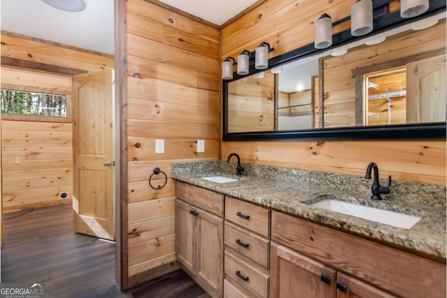 bathroom with hardwood / wood-style floors, vanity, and wood walls