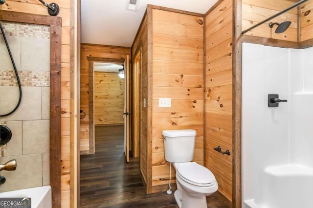 bathroom featuring a shower, hardwood / wood-style flooring, toilet, and wood walls